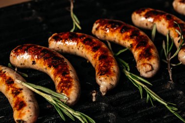 Izgara sosisler ızgarada, duman ve alevler arka planda, et pişirme kavramı. Yemek tarifi geçmişi. Kapatın. metin için yer,