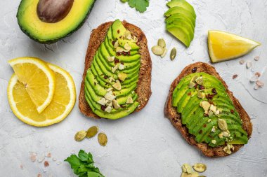 Taze yeşil Avokado sandviç çavdar ekmeği, kabak tohumu, tuz ve biber. Vejetaryen yemeği. Bitki temelli diyet. Temiz yemek. Üst Manzara. Boşluğu kopyala,