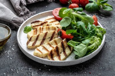 Beyaz tabakta ızgara Halloumi peynirli salata, Kıbrıs peyniri gıcırtısı. Restoran menüsü, diyet, yemek kitabı tarifi üst görünümü.