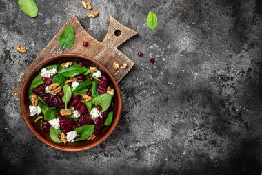 Taze ıspanaklı sağlıklı pancar salatası, peynir, fındık, kızılcık. Temiz yemek, diyet, vejetaryen yemek konsepti. Uzun afiş biçimi. en üstteki görünüm.