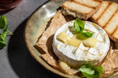 Fırında kamembert peyniri ve fesleğen yaprağı. Köy masasında ev yapımı ızgara peynir. afiş, menü, metin için tarif yeri, üst görünüm.