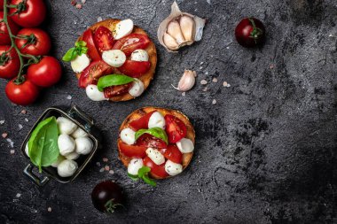 Mozzarella, kiraz domatesli ve taze fesleğenli Caprese tostları. Geleneksel İtalyan aperatifi veya aperatifi, antipasto. afiş, menü, metin için tarif yeri, üst görünüm.