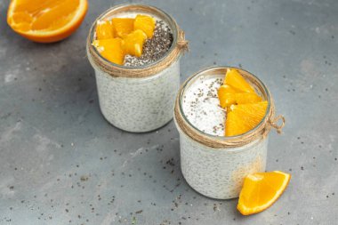 Narenciye ile süslenmiş camda laktozsuz yoğurt ile Chia Seed. Gri arka planda chia tohumlu yoğurt. sağlıklı süper yiyecekler. Sağlıklı yiyecekler. metin için yer.