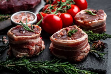 Çiğ mermer et, biftek fileminyonu. Eski et tavasında servis edilen domuz pastırmasına sarılı biftekler, yemek pişirme konsepti. Üst Manzara. metin için yer.