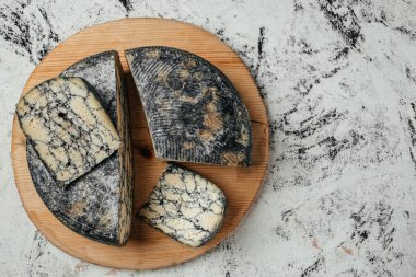 Tahtada mürekkep balığı mürekkebi olan Asago İtalyan peyniri. afiş, menü, metin için tarif yeri, üst görünüm.