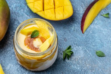 Kavanozda mango dondurması veya şerbet. Mavi arka planda ev yapımı meyveli mango dondurması, İtalyan tatlı dondurması..
