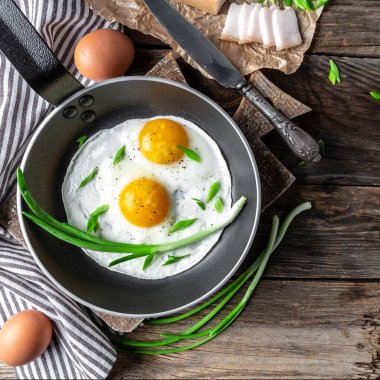 Ukrayna kahvaltısı kızarmış tavada yumurta, domuz yağı, ekmek ve yeşil tüylü soğan. en üstteki görünüm.