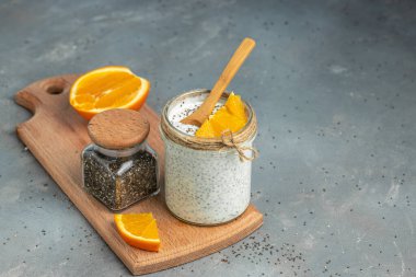 Narenciye ile süslenmiş camda laktozsuz yoğurt ile Chia Seed. Gri arka planda chia tohumlu yoğurt. sağlıklı süper yiyecekler. Sağlıklı yiyecekler. metin için yer.