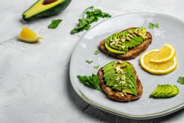 Avokado tostu. Kahvaltıda avokadoyla sağlıklı tost ya da çavdar ekmeğiyle öğle yemeği. Temiz yemek, diyet, vejetaryen yemek konsepti. en üstteki görünüm.