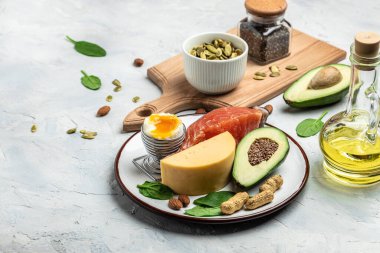 Düşük karbonhidratlı ürünleri yüksek proteinli ve iyi yağ kaynaklı yapın. Sağlıklı yağlar, hafif arka planda kilo vermek için temiz yiyecekler, keto ya da ketojenik diyet, uzun afiş formatı. en üstteki görünüm.