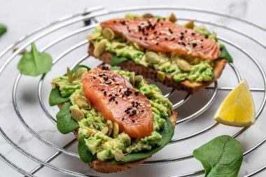 Avokado ezmeli ve somonlu tam tahıllı ekmek. Keto Paleo diyeti. Restoran menüsü, diyet, yemek kitabı tarifi üst görünümü.
