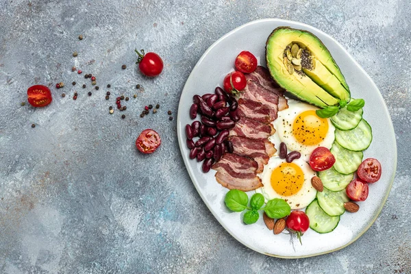 Sağlıklı besleyici paleo keto kahvaltı diyeti avokado, kızarmış yumurta, pastırma, fasulye ve kahve. Ketogenik diyet konsepti. Restoran menüsü, diyet, yemek kitabı tarifi üst görünümü.