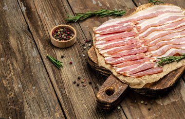 Tütsülenmiş domuz pastırması ince dilimlenmiş domuz eti dilimleri ahşap arka planda, ketojenik diyet, yazı için yer, üst görüş.,