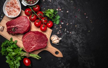 İki taze çiğ biftek ve arkaplanda pişmeye hazır baharatlar. Mutfak, yemek pişirme, konsept. afiş, menü, metin için tarif yeri, üst görünüm.