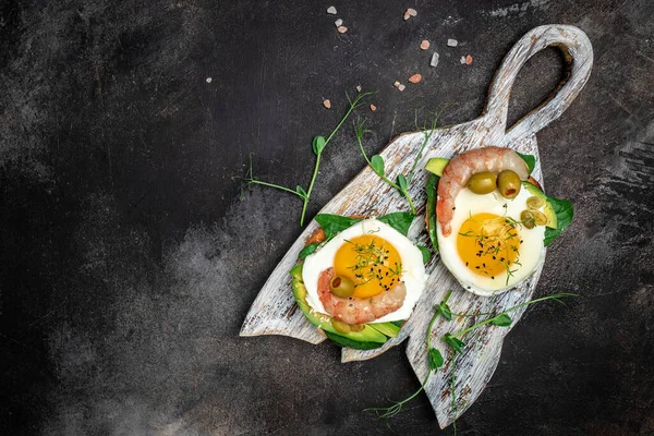 Два Тоста Цельнозерновым Хлебом Яйцом Шпинатом Авокадо Креветками Тёмном Фоне — стоковое фото