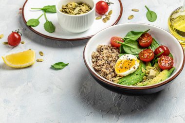 Keto diyet tabağı kinoa, avokado, yumurta, domates, ıspanak ve ayçiçeği tohumları. Sağlıklı yiyecekler, ketojenik diyet, diyet öğle yemeği konsepti, metin yeri, üst görünüm.