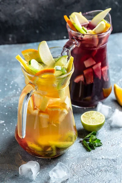 Cold drink from lemon slices in a glass decanter orange and berries, with ice cubes. detox water, vertical image. place for text,
