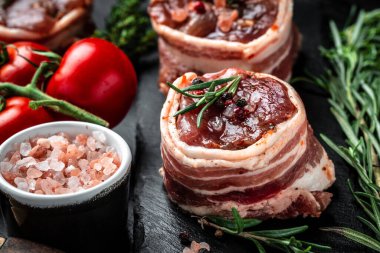 Çiğ mermer et, biftek fileminyonu. Eski kasap, aşçı ve yemek pişirme konseptinde servis edilen domuz pastırmasına sarılı madalyon biftekleri. Üst Manzara. metin için yer,