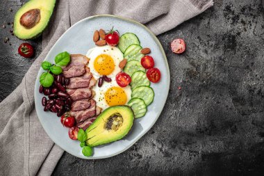 Avokado, sahanda yumurta, pastırma ve fasulyeyle Keto kahvaltısı. Paleo Keto kahvaltı diyeti öğle yemeği. Sağlıklı besleyici paleo keto kahvaltı konsepti. Yemek tarifi geçmişi. Kapat.,