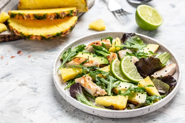 Salad of chicken breast with pineapple, avocado, green rocket salad, lime. Healthy juicy food. Food recipe background. Close up.