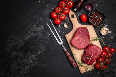 İki taze çiğ biftek ve arkaplanda pişmeye hazır baharatlar. Mutfak, yemek pişirme, konsept. afiş, menü, metin için tarif yeri, üst görünüm.
