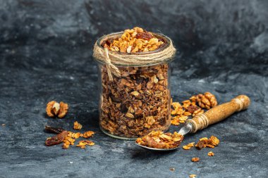 Bal tohumlu granola ve cam kavanozda kurutulmuş meyve. Lezzetli kahvaltı veya atıştırmalık, temiz yemek, diyet, vejetaryen yemek konsepti..