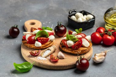 Mozzarella, kiraz domatesli ve taze fesleğenli Caprese tostları. Geleneksel İtalyan aperatifi veya aperatifi, antipasto. afiş, menü, metin için tarif yeri, üst görünüm.