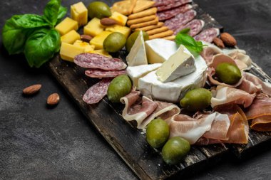 Antipasto tabağı İspanyol jamonu serrano ya da İtalyan prosciutto crudo, koyu arkaplanda İtalyan sert peynirli pecorino toscano. en üstteki görünüm.