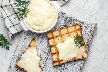 Kahvaltı için krem peynirli ve tereyağlı dilimlenmiş ekmek. Hafif arka planda erimiş peynirli sandviç. afiş, menü, metin için tarif yeri, üst görünüm.