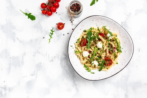 Domatesli Caprese salatalı makarna, mavi arka planda mozzarella sebze ezmesi, vejetaryen salatası, afiş, yazı için menü tarifi yeri, üst görünüm.,