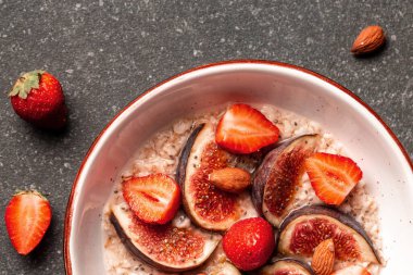 Sağlıklı kahvaltı yulaf ezmesi, incir parçaları, çilek ve chia tohumları bir kasede, glüten, laktozsuz, fitness yemeği, üst görünüm,