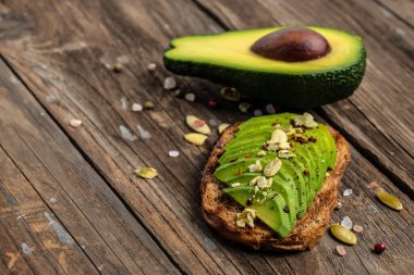 Çavdar ekmekli, balkabaklı, tuzlu ve biberli avokado sandviçi. Vejetaryen yemeği. Bitki temelli diyet. Temiz yemek, uzun afiş formatı. en üstteki görünüm,