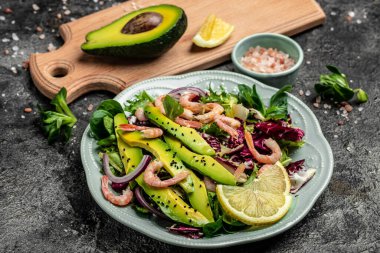 Taze avokado salatası, karides, marul yeşili karışım ve zeytinyağı, limon sosu. Sağlıklı yemek, lezzetli kahvaltı ya da atıştırmalık, temiz yemek, diyet, vejetaryen yemek konsepti. en üstteki görünüm.