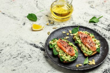 Avokadoo, somon ve ıspanak, fındık ve ayçekirdeği ile tost. Sağlıklı, temiz yemek. Vejetaryen ya da glütensiz diyet. Üst görünüm, boşluk kopyala.