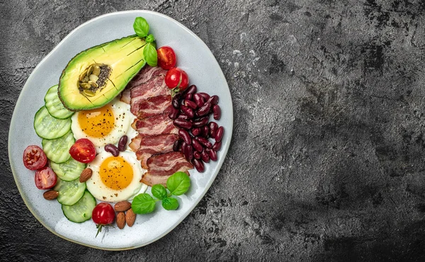 Ketogenik diyet öğün avokado, kızarmış yumurta, pastırma ve fasulye. Sağlıklı besleyici paleo keto kahvaltı diyeti öğle yemeği. Pankart, yemek servisi menü tarifi yeri, metin, üst görünüm.