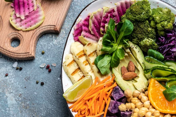 Halloumi peynirli Buda kasesi salatası, avokado, salatalık, nohut, karpuz turpu, patatesli tatlı. Ketojenik paleo diyeti. Temiz yemek, diyet, vejetaryen yemek konsepti. en üstteki görünüm.