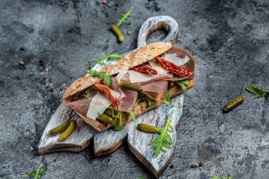 Prosciutto sandviçi, jambonlu Ciabatta, kurutulmuş domatesler, turşu, parmesan ve roka, afiş, menü, metin için tarif yeri.,