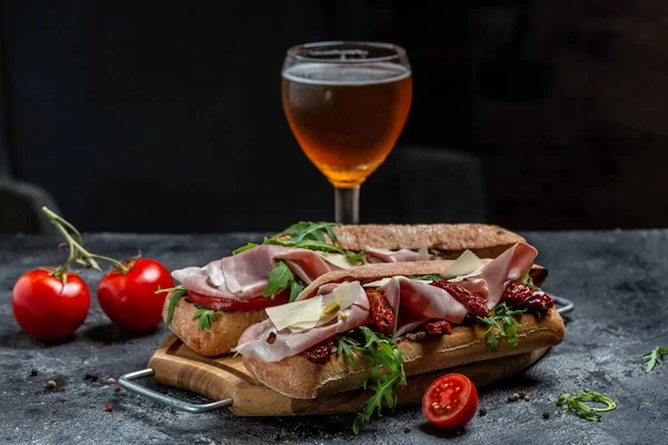 sandwich with beer. Turkey sandwich with ham, tomato, parmesan and arugula. appetizer bruschetta, Delicious breakfast or snack.