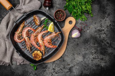 Baharatlı, limonlu ve sarımsaklı ızgara kaplan karidesi. Koyu bir arka planda kızartılmış karidesler, deniz ürünleri aperatifleri, aşçılık konsepti, üst manzara.,
