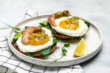 Tost ekmeği, yağda yumurta, ıspanak, avokado, karides ve ketogenik kahvaltı. Süper yiyecek konsepti. Sağlıklı, temiz yemek. Üst görünüm.