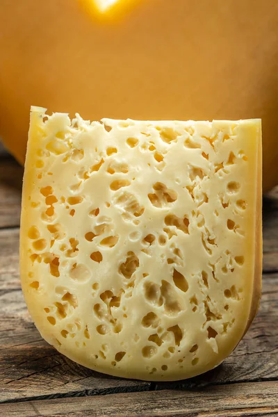 Tahta Arka Planda Büyük Delikleri Olan Yarı Sert Fransız Peyniri — Stok fotoğraf