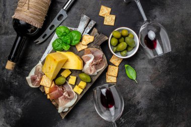 Antipasto tabağı İspanyol jamonu serrano ya da İtalyan prosciutto crudo, koyu arkaplanda İtalyan sert peynirli pecorino toscano. en üstteki görünüm.