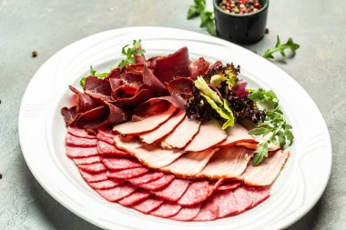 Pişmiş et tabağı dilimlenmiş jambon, sosis, jambon, jambon. Etli antipasto, pankart, menü, metin için tarif yeri, üst görünüm,