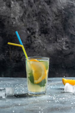 Yaz köpüklü kokteyller. Limonlu, portakallı ve naneli maden suyu kokteyli. Bir bardak soğuk içecek. dikey görüntü. metin için yer.