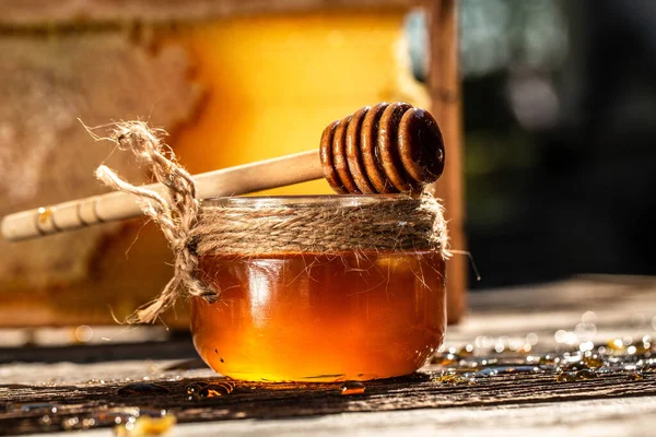 天然のハニカムと木製のテーブルの上のガラス瓶 蜂蜜の背景 ミツバチの製品は有機天然成分の概念によるもので — ストック写真
