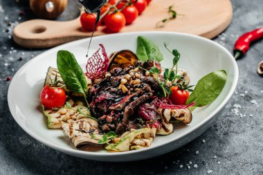 Izgara sebze, fındık, sos ve parmesanla dilimlenmiş biftek barbeküsü. İtalyan mutfağı konsepti. afiş, menü, metin için tarif yeri, üst görünüm.