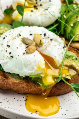 Tahta masada ıspanaklı sandviç, avokado, yumurta ve balkabağı tohumu, sağlıklı yemek, keto diyeti, diyet öğle yemeği konsepti. dikey görüntü. Üst Manzara. metin için yer.