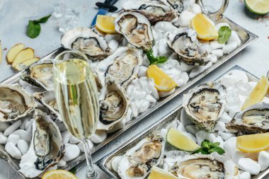 Şarap, limon ve kabartma bıçağıyla istiridye. Restoranda şampanyayla istiridye yemeği. afiş, menü, metin için tarif yeri, üst görünüm.