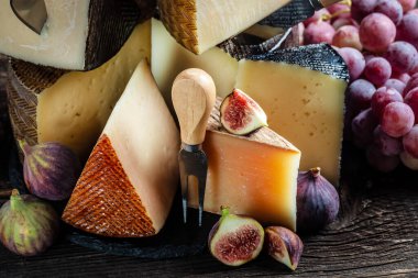 Üzüm ve incirli farklı peynir çeşitleri. Peynir arka planı. Geleneksel İspanyol, Fransız, İtalyan peyniri parçaları.