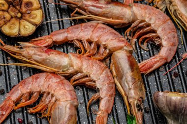 Baharatlı, limonlu ve sarımsaklı ızgara kaplan karidesi. Koyu bir arka planda kızartılmış karidesler, deniz ürünleri aperatifleri, aşçılık konsepti, üst manzara.,